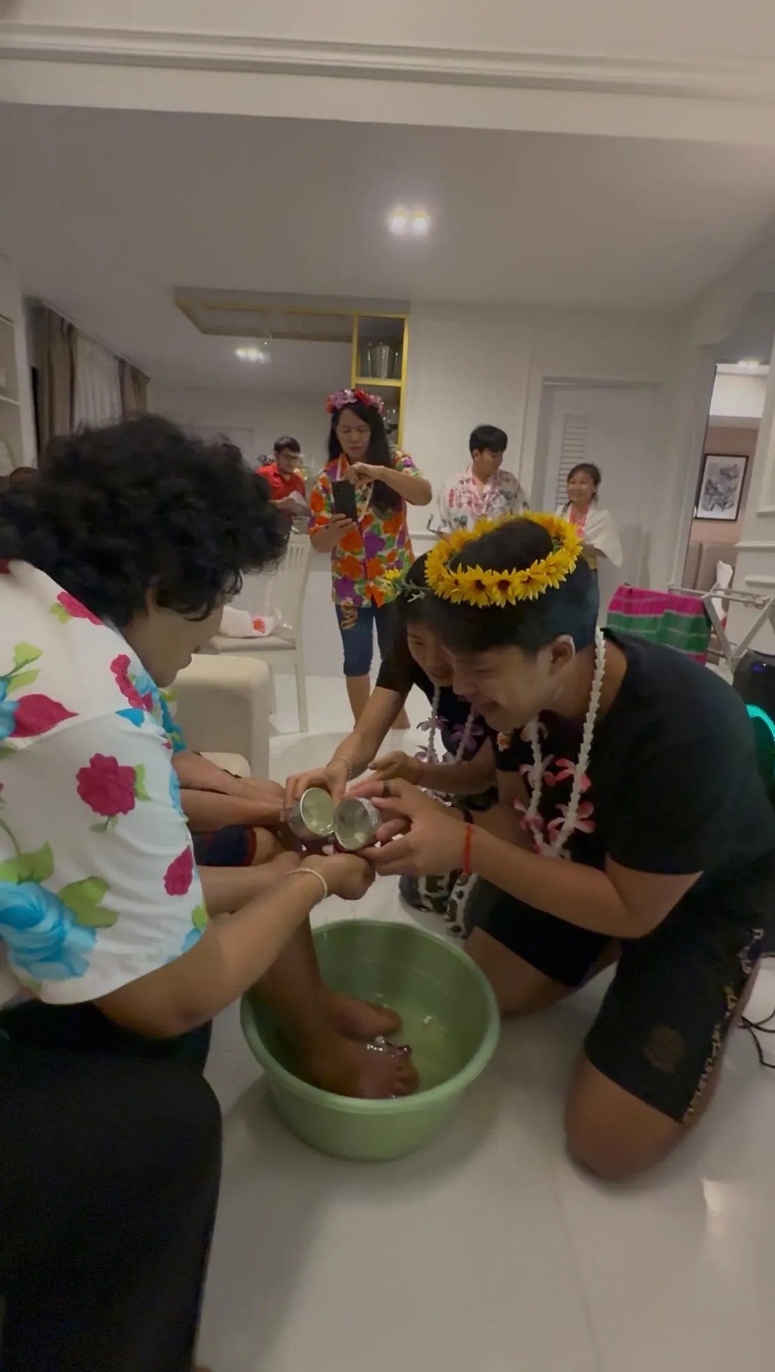 Family members sharing a traditional water blessing at home